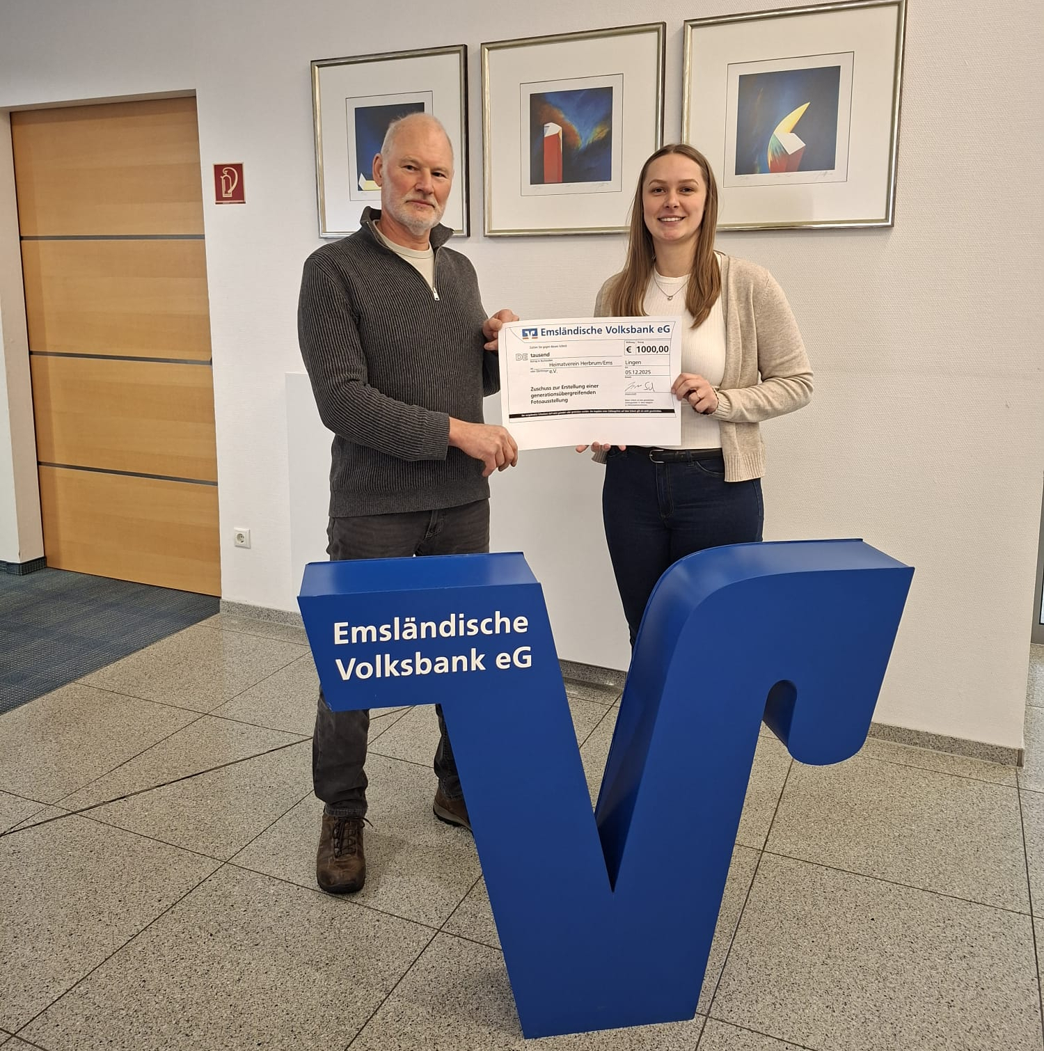 Das Foto zeigt den 2. Vorsitzenden Theo Norda bei der Übergabe des Zuschusses mit der Mitarbeiterin des Emsl. Volksbank Lena Husmann